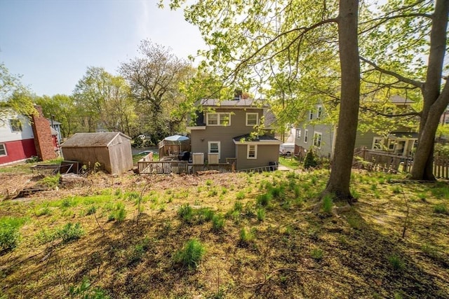 view of yard featuring an outdoor structure, a deck, and a shed