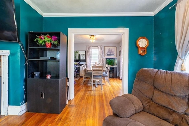 living area featuring crown molding and hardwood / wood-style flooring