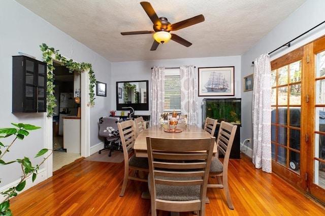 dining space with a textured ceiling, ceiling fan, a wealth of natural light, and wood finished floors