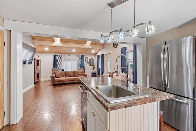 kitchen with pendant lighting, a center island with sink, white cabinetry, appliances with stainless steel finishes, and sink