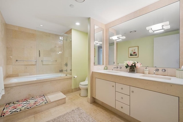 full bathroom featuring tile patterned flooring, vanity, tiled shower / bath combo, and toilet