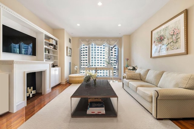 living room with hardwood / wood-style floors and built in shelves