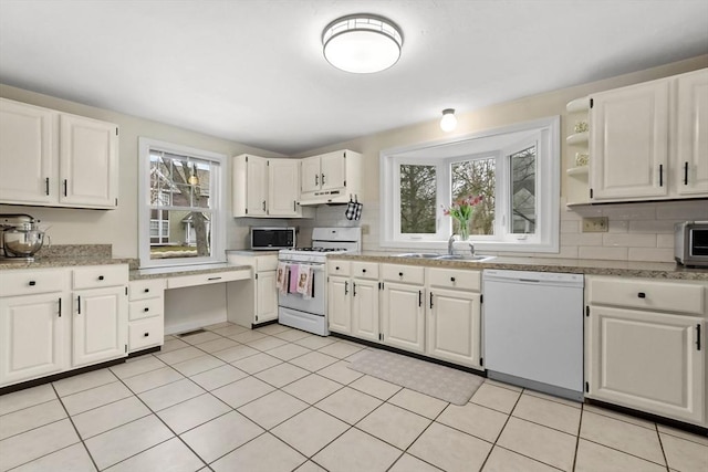 kitchen featuring decorative backsplash, white appliances, light countertops, and under cabinet range hood