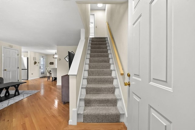 stairway with wood finished floors and baseboards