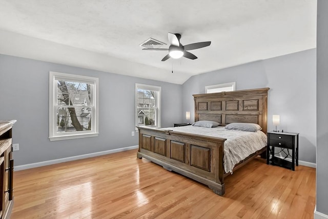 bedroom featuring visible vents, lofted ceiling, light wood finished floors, baseboards, and ceiling fan