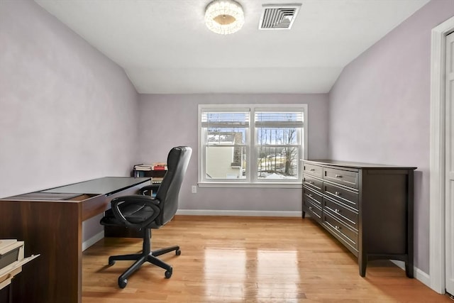 office area with vaulted ceiling, light wood-style flooring, baseboards, and visible vents