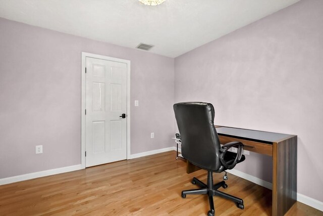 office space featuring visible vents, baseboards, and wood finished floors