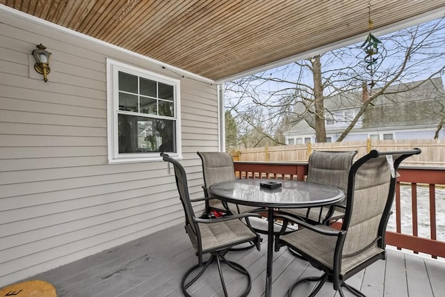 deck with outdoor dining area and fence