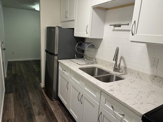 kitchen with white cabinetry, dark hardwood / wood-style flooring, light stone counters, and sink