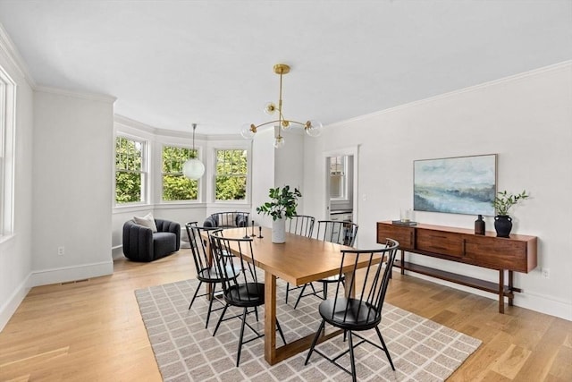 dining area featuring baseboards, a notable chandelier, ornamental molding, and light wood-type flooring