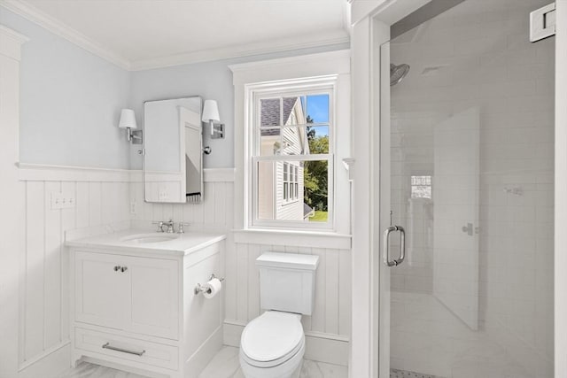 bathroom featuring wainscoting, toilet, marble finish floor, a shower stall, and ornamental molding