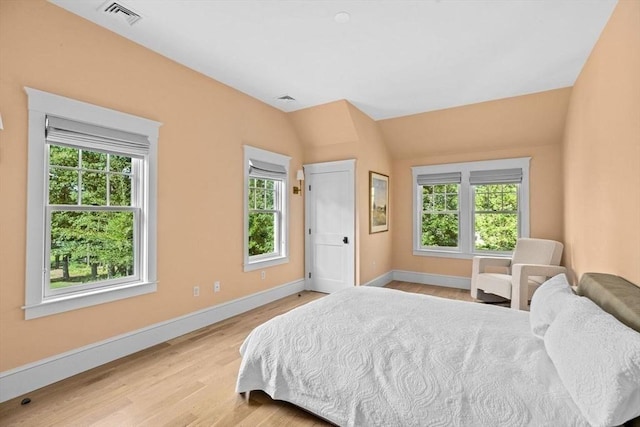 bedroom featuring baseboards, visible vents, and wood finished floors