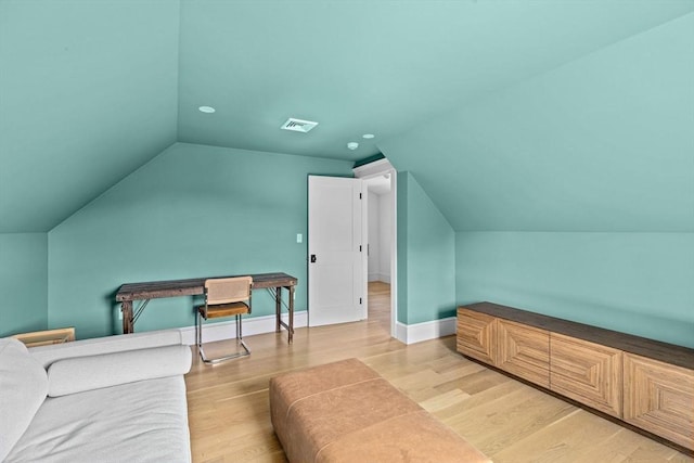 bedroom featuring visible vents, baseboards, light wood-style floors, and lofted ceiling
