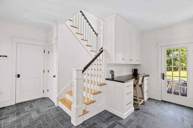 stairway with ornamental molding and built in desk