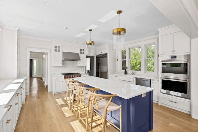 kitchen with white cabinets, extractor fan, light wood-style flooring, stainless steel appliances, and backsplash