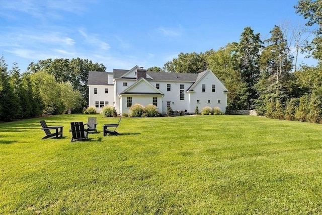 back of property featuring a lawn and a chimney