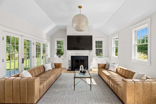 living room featuring a fireplace with flush hearth, french doors, and lofted ceiling