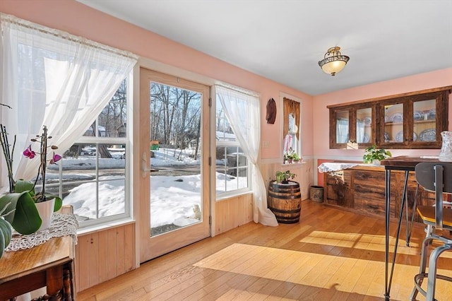 doorway featuring light wood-style floors and wainscoting