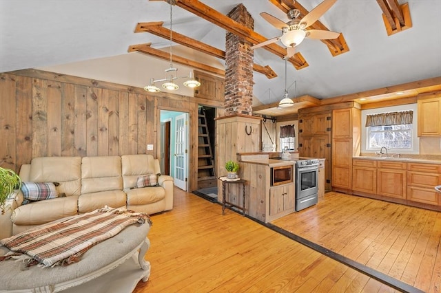 kitchen featuring lofted ceiling with beams, light wood-style flooring, a sink, electric stove, and open floor plan