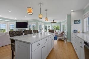 kitchen with a wealth of natural light, white cabinets, and decorative light fixtures