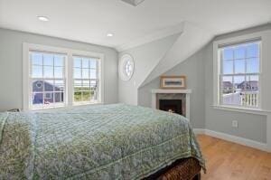 bedroom with hardwood / wood-style floors and lofted ceiling