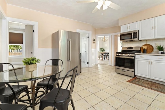 162 Park St Unit 1, Beverly, MA 01915 - kitchen with stainless steel appliances, white cabinetry, ceiling fan, light tile patterned flooring, and backsplash