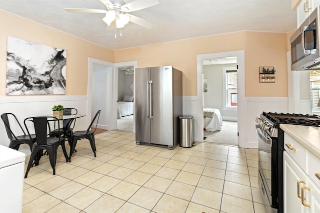 162 Park St Unit 1, Beverly, MA 01915 - kitchen featuring appliances with stainless steel finishes, a ceiling fan, plenty of natural light, a wainscoted wall, and light countertops