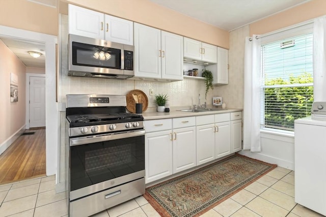 162 Park St Unit 1, Beverly, MA 01915 - kitchen with appliances with stainless steel finishes, washer / clothes dryer, light countertops, white cabinets, and a sink