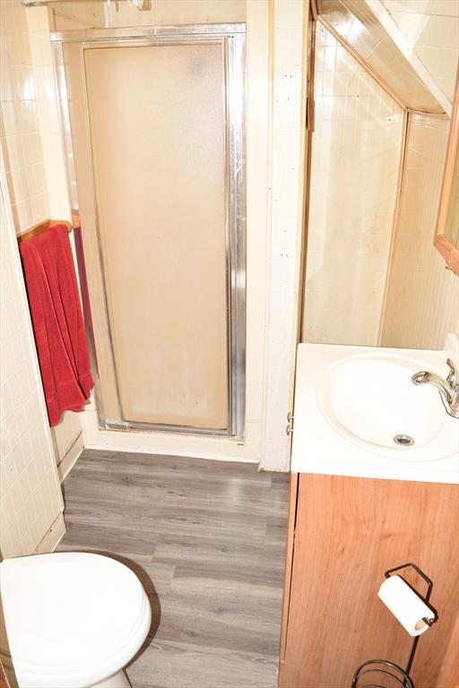 1407-1409 Worcester St, Springfield, MA 01151 - bathroom featuring a shower stall, vanity, wood finished floors, and toilet