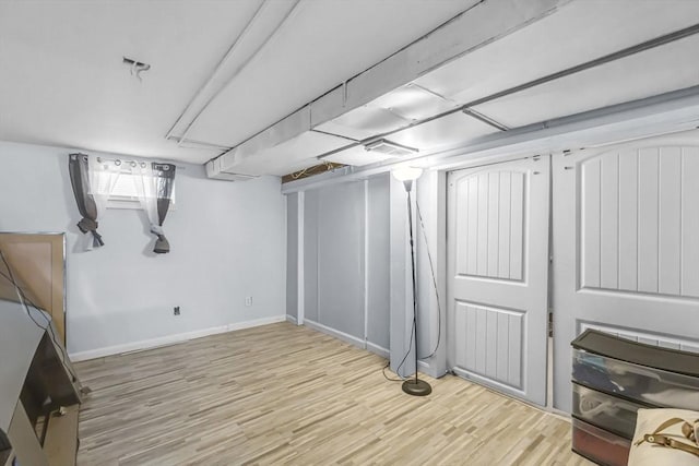 basement with light hardwood / wood-style floors