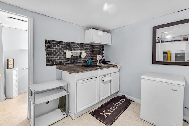 kitchen with white cabinetry, tasteful backsplash, and refrigerator