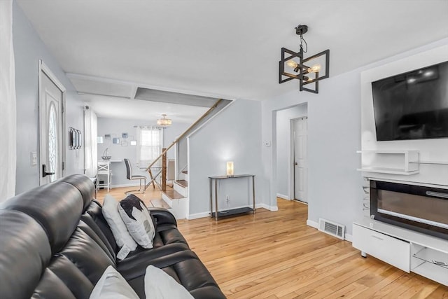 living room featuring an inviting chandelier and light wood-type flooring