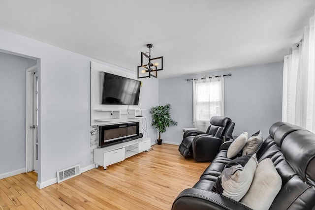 living room featuring a chandelier and light wood-type flooring