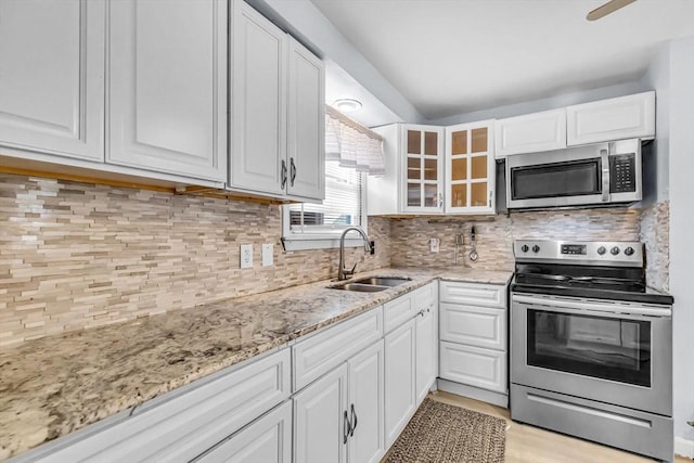 kitchen featuring tasteful backsplash, stainless steel appliances, sink, and white cabinets