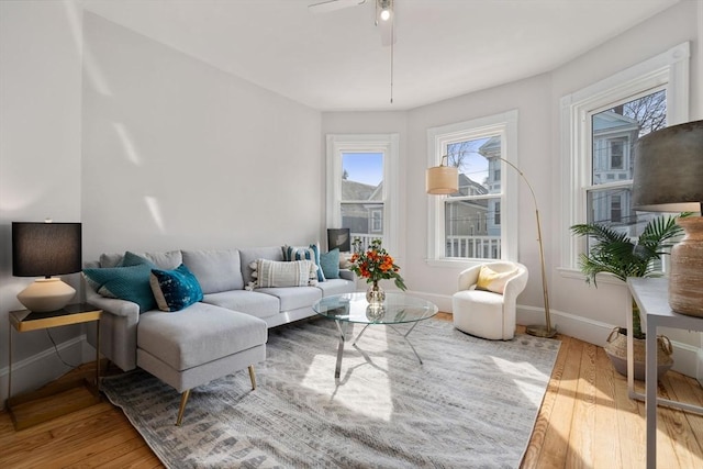 living area with ceiling fan, baseboards, and wood finished floors