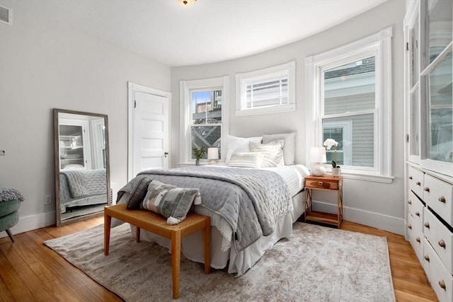 bedroom with visible vents, baseboards, and light wood-style floors