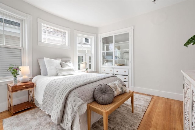 bedroom featuring baseboards and light wood finished floors