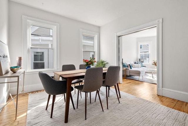 dining room with light wood-type flooring and baseboards