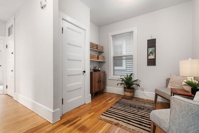 living area featuring light wood-type flooring and baseboards