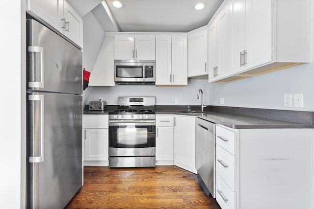 kitchen featuring white cabinetry, appliances with stainless steel finishes, sink, and dark wood-type flooring