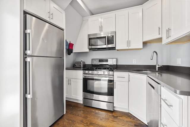 kitchen featuring appliances with stainless steel finishes, sink, white cabinetry, and dark hardwood / wood-style flooring