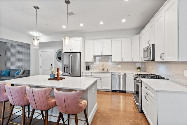 8 Sanborn St Unit 2012, Reading, MA 01867 - kitchen with appliances with stainless steel finishes, a sink, recessed lighting, backsplash, and white cabinets