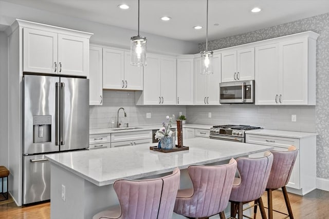 8 Sanborn St Unit 2012, Reading, MA 01867 - kitchen featuring premium appliances, a sink, a kitchen island, wood finished floors, and recessed lighting