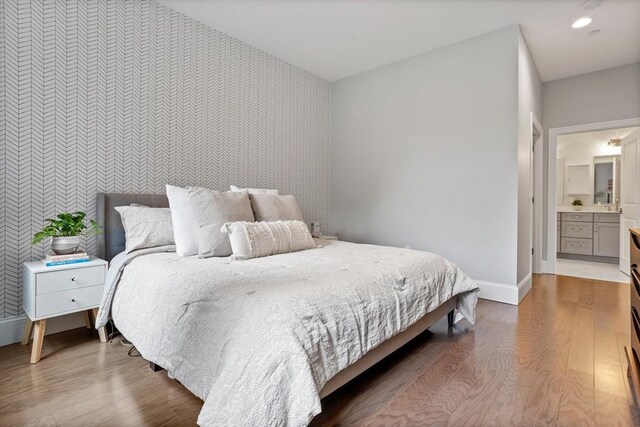 8 Sanborn St Unit 2012, Reading, MA 01867 - bedroom with wallpapered walls, an accent wall, wood finished floors, and baseboards