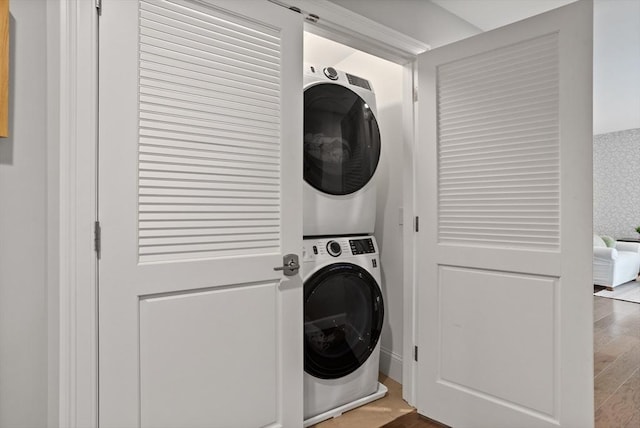 8 Sanborn St Unit 2012, Reading, MA 01867 - washroom featuring stacked washing machine and dryer and wood finished floors