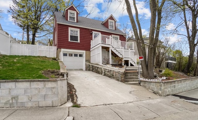 view of front facade featuring fence, a shingled roof, an attached garage, stairway, and concrete driveway