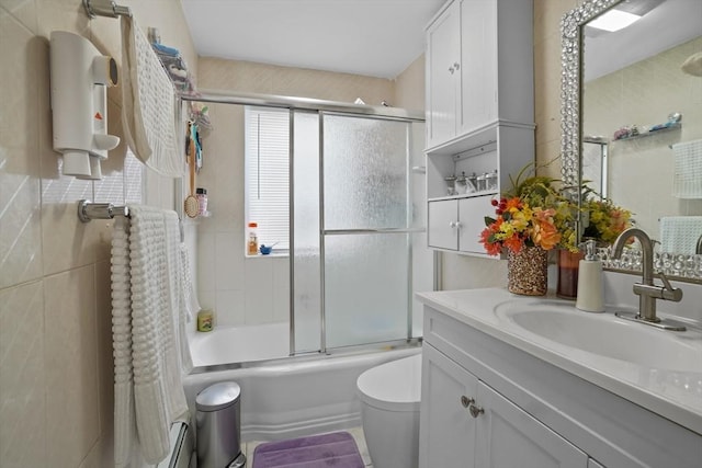 full bath with vanity, enclosed tub / shower combo, toilet, and tile walls