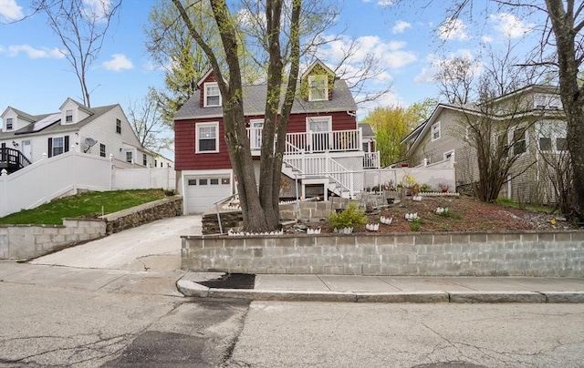 view of front of house with a residential view, a garage, stairway, concrete driveway, and covered porch
