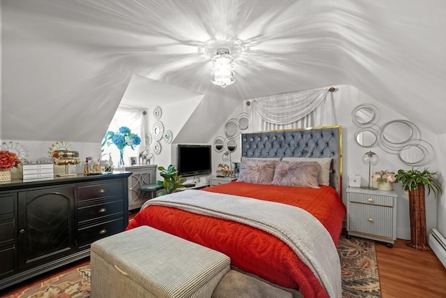 bedroom with a baseboard radiator, vaulted ceiling, and wood finished floors