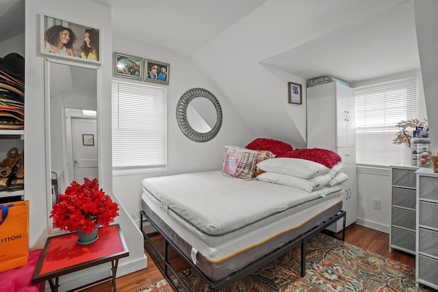 bedroom featuring wood finished floors and lofted ceiling